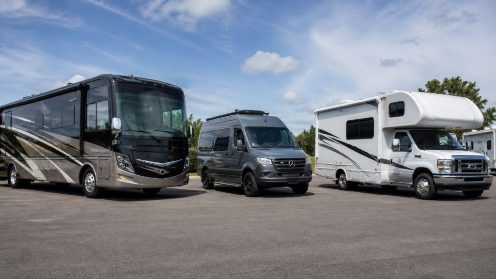 Class A motorhome, Class B camper van, and Class C motorhome shown side by side in a clean RV display lot