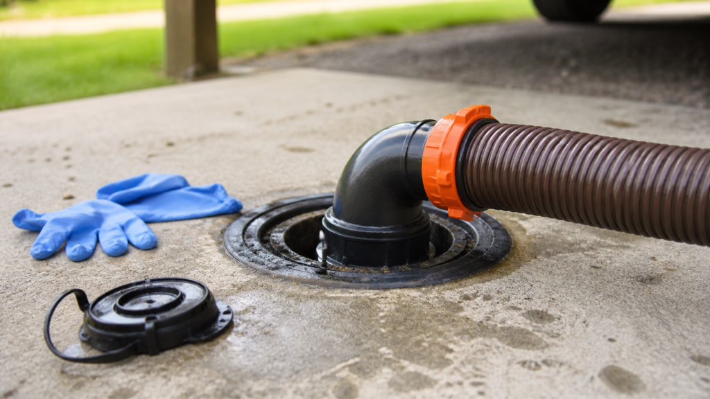 Close-up of an RV sewer hose clear elbow securely connected to a campground dump inlet